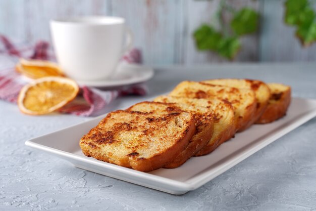 Toast alla francese con tè su uno sfondo grigio