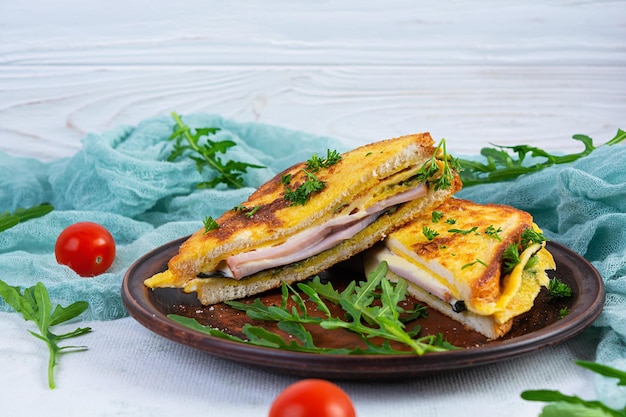 Toast arrosto in uova strapazzate con prosciutto alle erbe e formaggio cheddar Delizioso panino per la colazione alla griglia