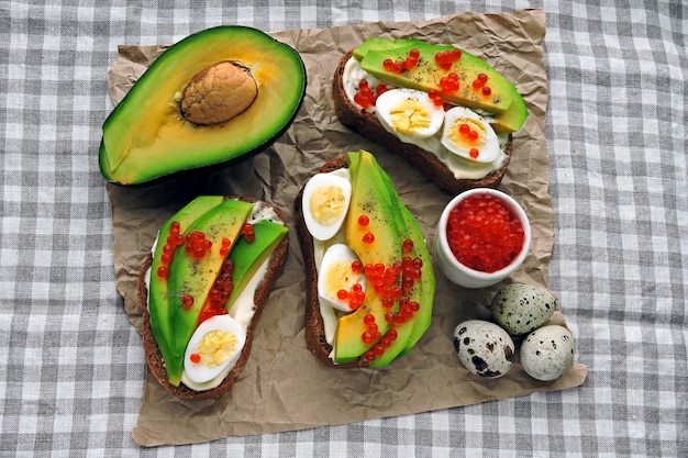 Toast avocado sano con uova di quaglia e caviale rosso. Dieta Keto. Brindisi di Keto