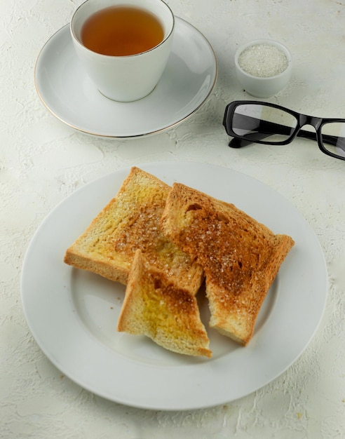 toast con burro e zucchero servito con una tazza di tè