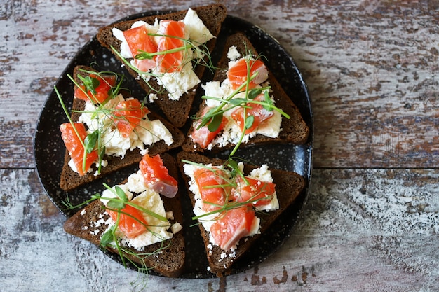 Toast con salmone e formaggio bianco su un piatto. Dieta Keto. Brindisi di Keto.