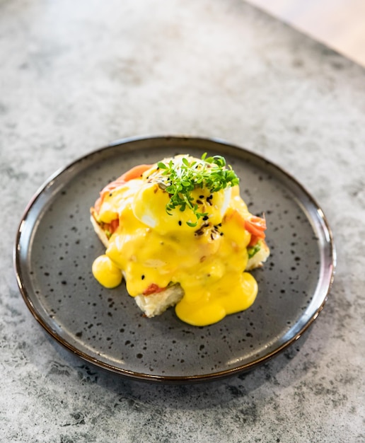 Toast con salmone, uovo in camicia, avocado e salsa olandese Toast con uovo alla Benedict e salmone