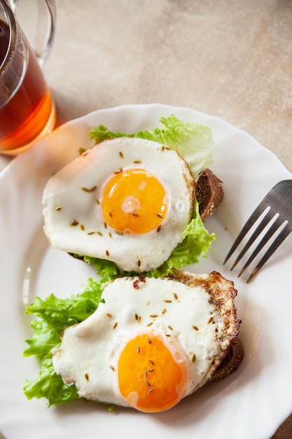 Toast con uova fritte vicino al tè caldo