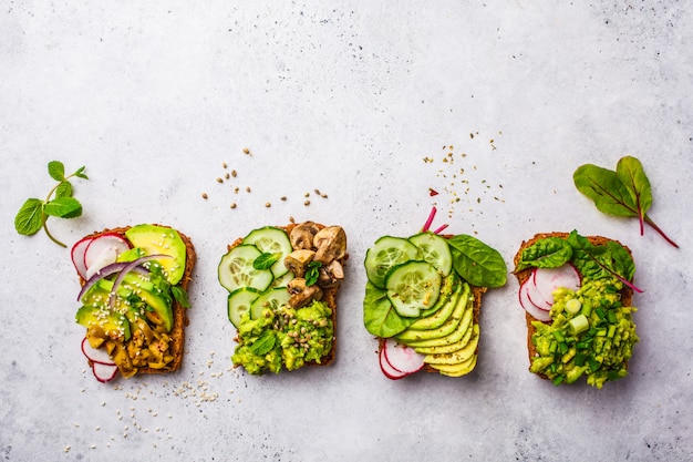 Toast di avocado con diversi condimenti, vista dall&#39;alto, sfondo bianco, copia spazio.