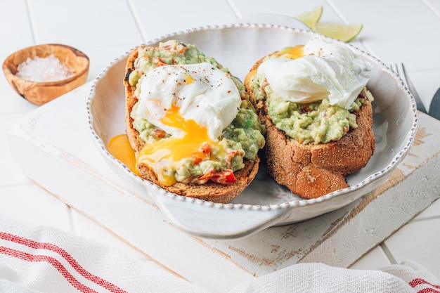 Toast di avocado con uova in salamoia Concetto di colazione sana