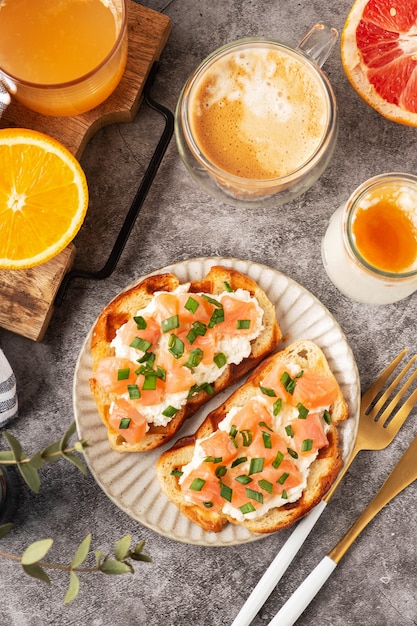 Toast di formaggio e salmone, concetto di colazione con caffè e succo d'arancia appena spremuto, cibo sano.