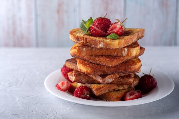 Toast francese con fragole alla cannella e menta per la colazione del mattino con caffè o tè