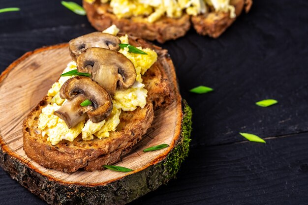 Toast integrale con uova strapazzate con funghi e ricotta. sana colazione o brunch. Menu del ristorante, dieta, ricetta del libro di cucina.