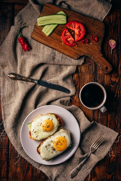 Toast per la colazione con verdure e uova fritte con una tazza di caffè