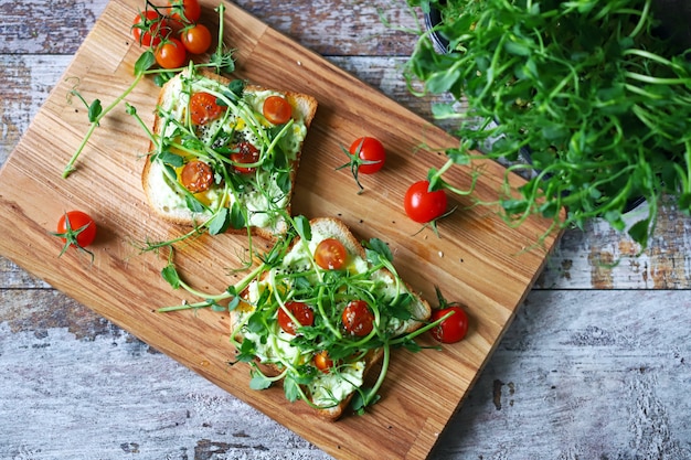 Toast sani con pasta di avocado, pomodorini e microgreens.