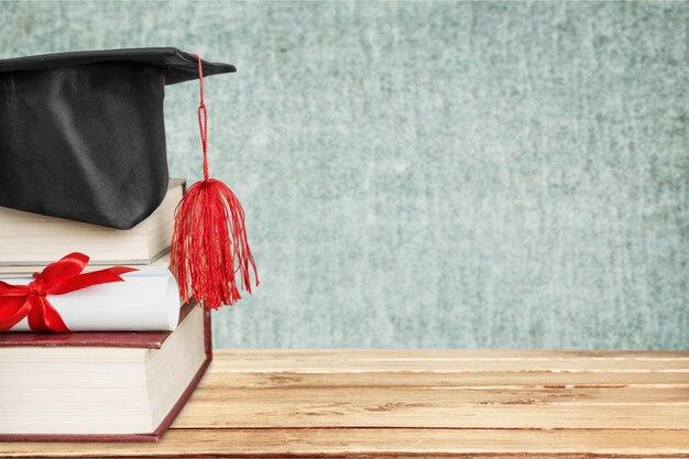 Tocco di laurea in cima alla pila di libri