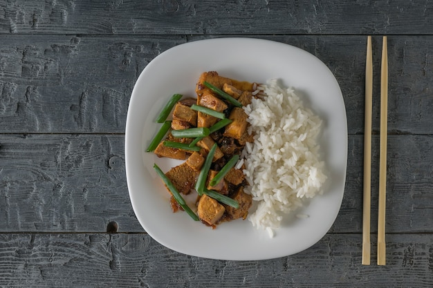Tofu arrosto con riso e salsa di soia sul tavolo. Lay piatto. Piatto asiatico vegetariano.