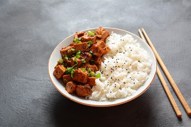 Tofu gustoso in teriyaki con riso su un piatto