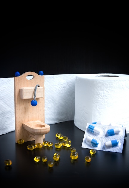 Toilette, capsule e carta di legno del giocattolo su fondo nero