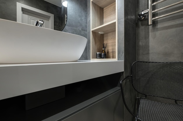 Toilette e dettaglio di una cabina doccia ad angolo con attacco doccia a parete