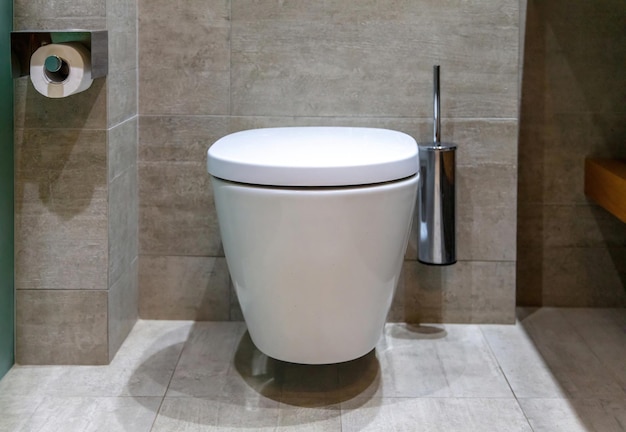 Toilette moderna con design d'interni per WC sospeso e pareti e pavimento piastrellati con spazzole