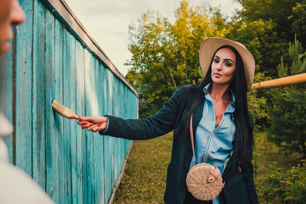 Tom Sawyer, una bella donna con un cappello di paglia in piedi davanti alla staccionata, la donna ha dipinto una staccionata di legno