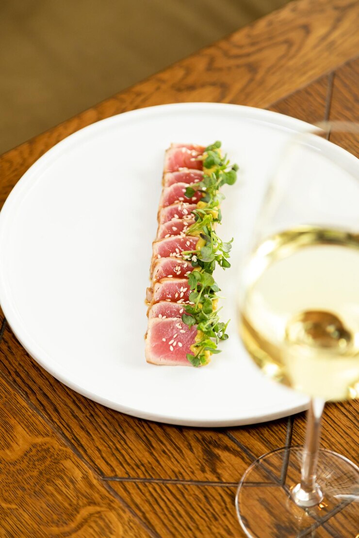 Tonno su un piatto bianco guarnito con erbe fresche