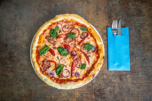 Top of wiev pizza italiana con posate sul tavolo in pizzeria.