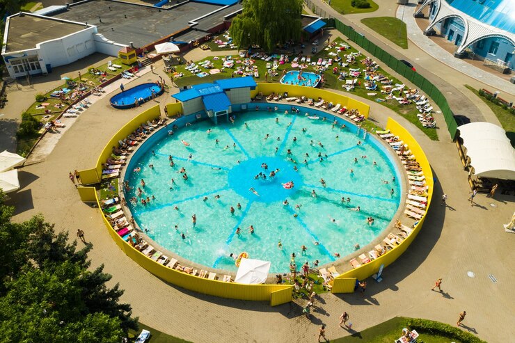 Top view of an outdoor place for people to relax where there is a swimming pool and a lot of sun beds