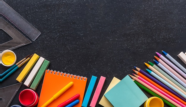 Torna al concetto di scuola. Articoli di cancelleria su sfondo nero