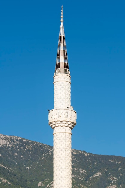 Torre bianca della moschea contro il cielo blu
