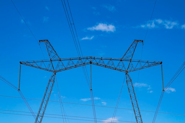 Torre con fili di trasmissione di energia ad alta tensione contro il cielo blu