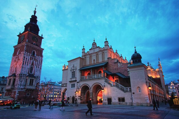 Torre del municipio e sala dei panni nella piazza del mercato principale della città vecchia di Cracovia in Polonia. Illuminato a tarda sera