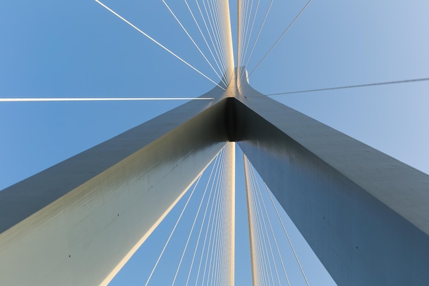 Torre del ponte con cavi di soggiorno contro uno sfondo di struttura astratta di cielo blu