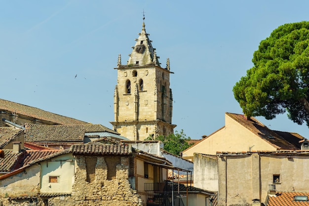 Torre della chiesa gotica di Torrelaguna sui tetti di vecchie case in rovina Madrid