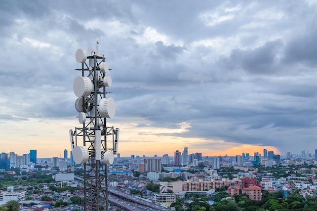 Torre delle telecomunicazioni con antenna di rete cellulare 5G sullo sfondo della città