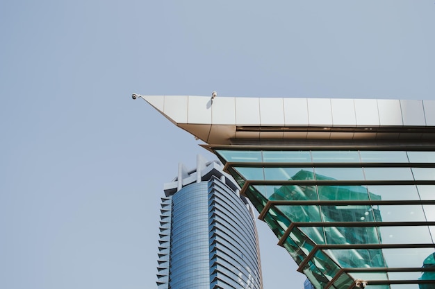 Torre di affari del grattacielo di vetro ad alta tecnologia moderna diurna ed edificio residenziale con cielo blu