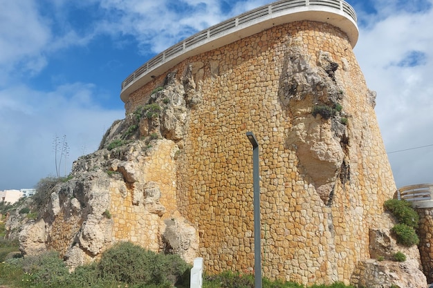 Torre di guardia in pietra su una scogliera con cielo limpido Fotografia di architettura storica