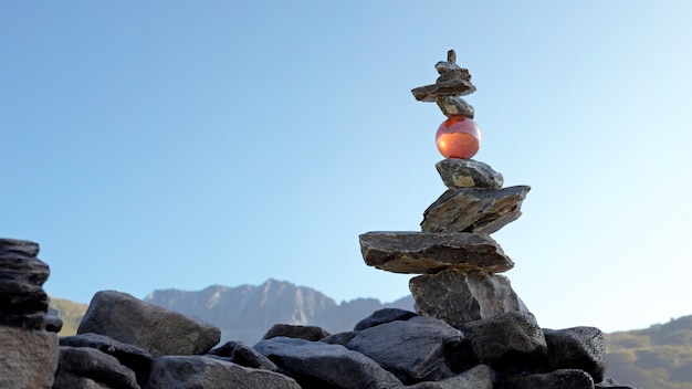 Torre di pietre in equilibrio (Rock Balance) con una sfera di cristallo che regge le pietre superiori.