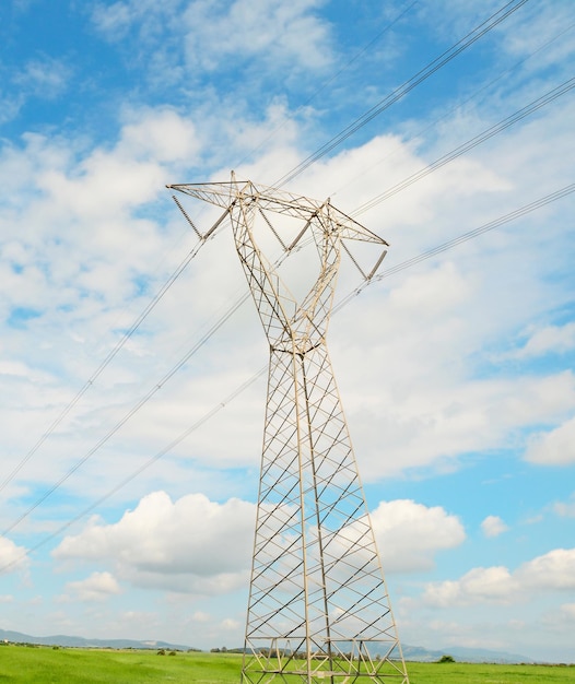 Torre di trasmissione in campagna sotto un cielo blu