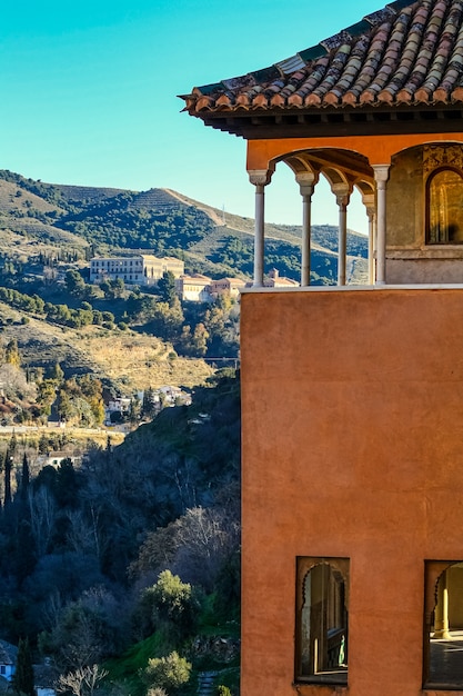 Torre islamica dell'Alhambra di Granada con la montagna sullo sfondo.