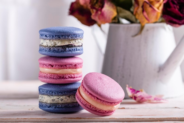 Torre una pila di amaretti rosa e blu su uno sfondo chiaro