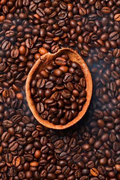 Torrefazione di chicchi di caffè con fumo su uno sfondo scuro caffè Arabica o robusta sfondo caffè Vista superiore