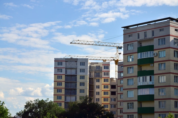 Torri della gru di costruzione alta e pesante contro un cielo blu