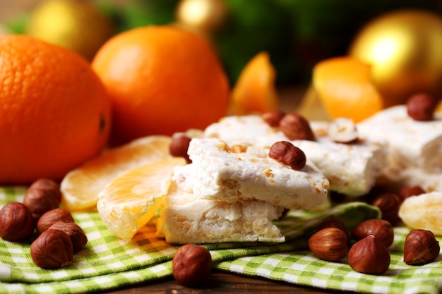 Torrone dolce con arance e decorazioni natalizie sul tavolo da vicino