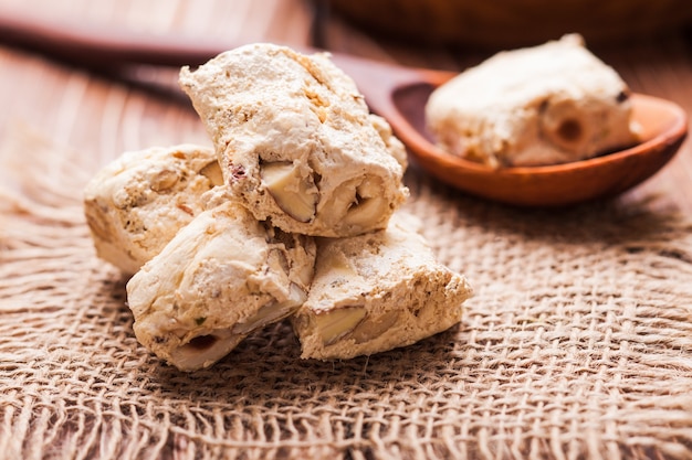 Torrone, dolce tipico italiano con noci su una tavola rustica