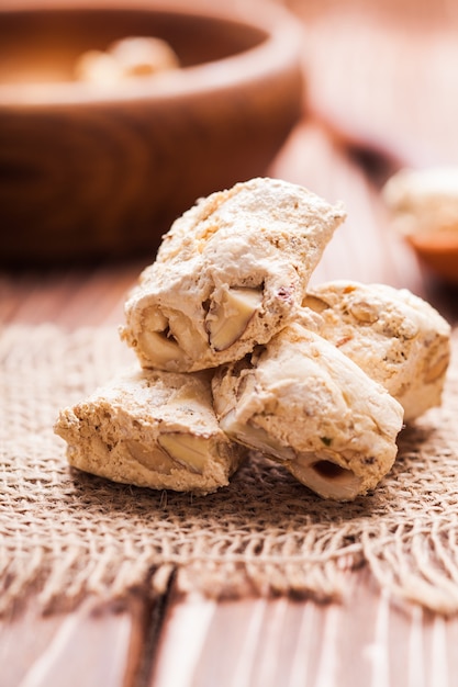 Torrone, dolce tipico italiano con noci su una tavola rustica