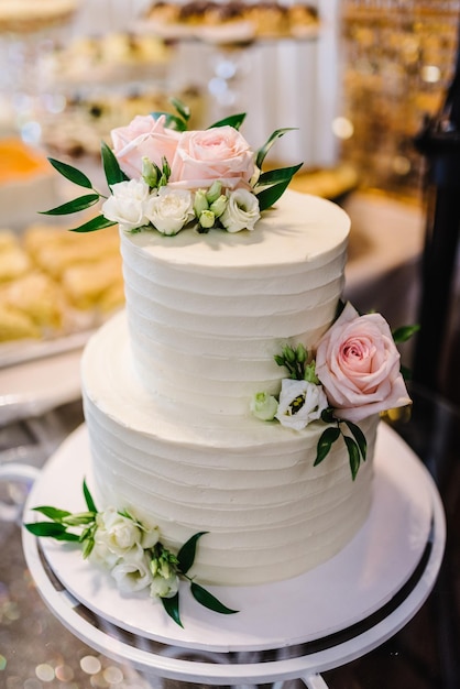 Torta a castello bianca decorata con fiori rosa Elegante torta nuziale per gli sposi Torta di compleanno con decorazioni dorate