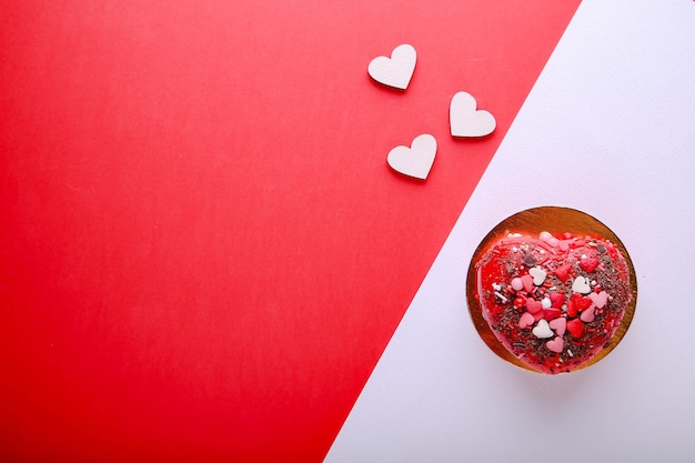 Torta a forma di cuore su fondo rosso. San Valentino.