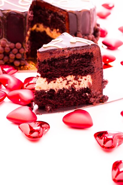 Torta al caramello salato a forma di cuore su sfondo bianco.