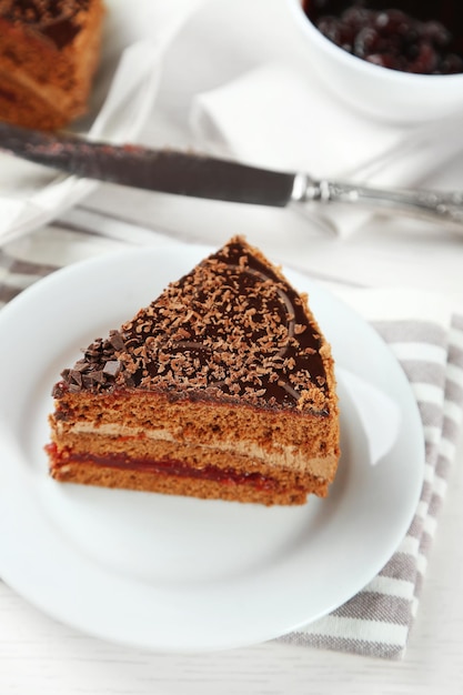 Torta al cioccolato affettata sul piatto sul fondo della tavola in legno