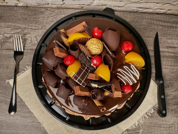 Torta al cioccolato con decorazione di cioccolatini ciliegia e pesca vista dall'alto