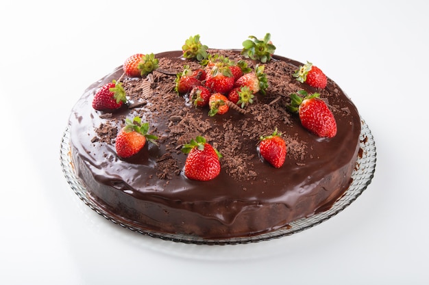 Torta al cioccolato con fragole isolato su superficie bianca.