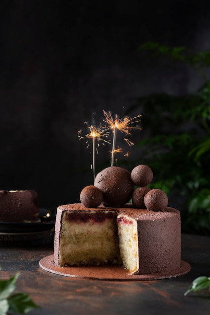 Torta al cioccolato con le stelle filanti di natale su un backgroud scuro, immagine del fuoco selettivo