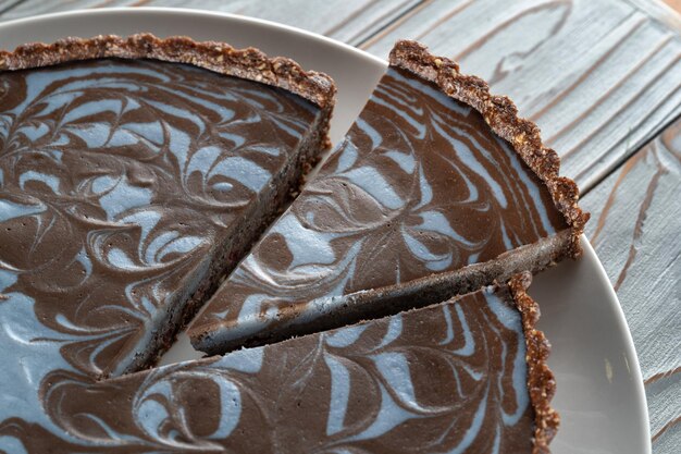 Torta al cioccolato con noci posate su un piatto Pezzo ben tagliato Fondo in legno spazzolato